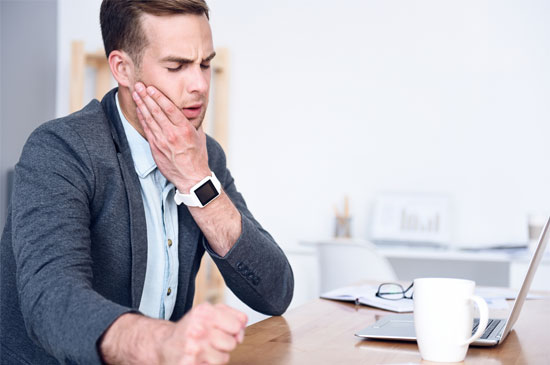 Jaw Pain Man Holding jaw in pain